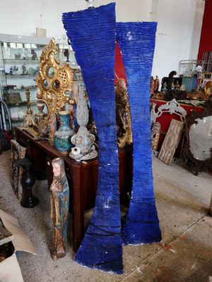 deux grands vases bleus posés sur une table au milieu d'une pièce