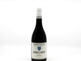 the bottle of wine is sitting on a white surface