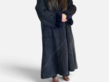 woman wearing a black robe and hat standing in front of a white background