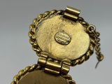 a close up of a gold plated watch with a chain around it