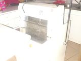a white refrigerator in a kitchen with a red wall