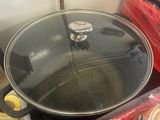 a pan with a lid sitting on a table next to other containers
