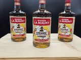 trois bouteilles d'alcool posées sur une caisse en bois