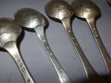 six spoons are lined up on a table with a white background