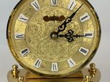 a gold clock with roman numerals on top of it