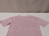 a pink t - shirt sitting on top of a white table