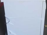a white refrigerator sitting on a cart in a garage