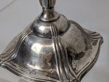 a silver candle that is sitting on a glass table