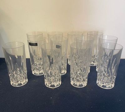 Six verres sont alignés sur une table recouverte d'une nappe noire.