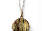 a close up of a gold locke on a white string