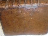 une valise marron posée sur une table blanche