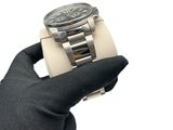 someone is holding a watch in their hand and wearing a glove