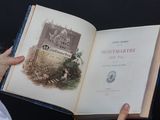 une personne tenant un livre ouvert sur lequel figure l'image d'un château