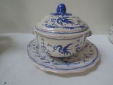 a blue and white bowl and saucer on a white table
