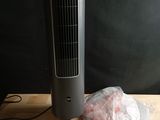 un ventilateur posé sur une table à côté d'un sac de provisions