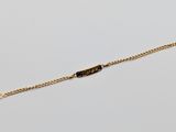a gold chain bracelet with a bar on it