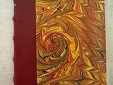 un livre à la couverture rouge posé sur une surface blanche