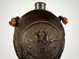 an old metal flask with a design on it
