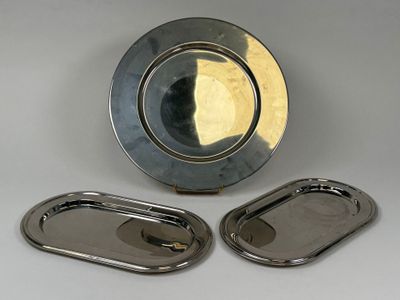 des assiettes et des plateaux en argent posés sur une surface blanche