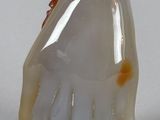 a white and gold figurine of a person with a hat on