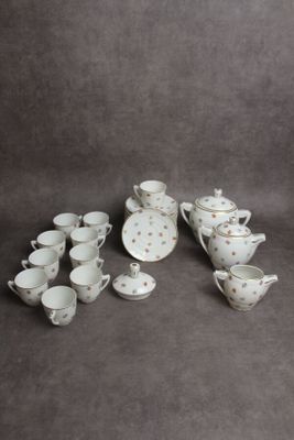 une image représentant un ensemble de tasses et soucoupes à thé et à café blanches et dorées
