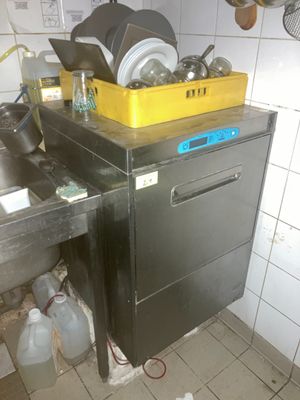 une photo d'une cuisine sale avec beaucoup de désordre sur le plan de travail
