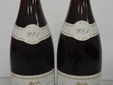 two bottles of wine sitting on top of a table next to each other