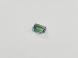 a green tourmaline stone on a white surface