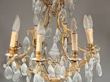 an antique brass chandelier with crystal drops hanging from the ceiling