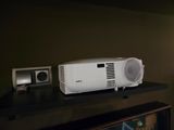un projecteur blanc posé sur une étagère noire