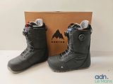 the snowboard boots are next to the box on the table