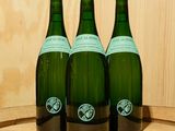 trois bouteilles de vin posées sur un tonneau en bois