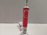 a pink toothbrush sitting on a white table