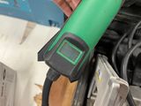 a person holding a green and black tool in their hand