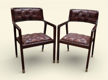 pair of brown leather chairs on a white background