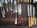 many different types of silverware laid out on a table
