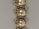 une image représentant un bracelet en argent orné de cinq cercles