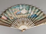 a fan with a painting on it hanging on a wall