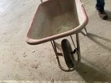 a man pushing a wheelbarrow in a parking garage