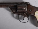 a close up of a revolver with a wooden handle on a table