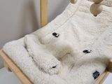 a teddy bear that is laying down on a blanket
