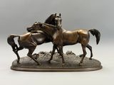 sculpture en bronze représentant deux chevaux sur un rocher, sur fond blanc