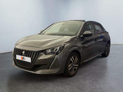 La voiture grise est garée dans une grande pièce au sol noir.