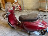 a red scooter that is parked in a garage