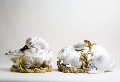 two white and gold figurines sitting next to each other