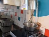 a kitchen with a stove, stove top, and a bowl on the counter