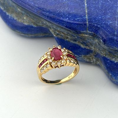 an image of a gold ring with a ruby and diamond set in it