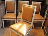 Plusieurs chaises sont alignées dans une pièce, avec une statue en arrière-plan.