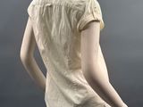 mannequin dressed in a yellow shirt and khaki pants on a mannequin stand