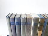 several books are stacked on top of each other on a shelf